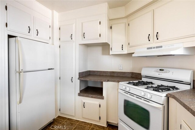 32540 San Miguelito Dr, Thousand Palms, CA 92276 - kitchen with white appliances, under cabinet range hood, dark countertops, and white cabinets