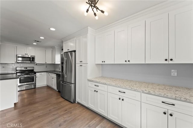 19408 Campaign Dr, Carson, CA 90746 - kitchen with appliances with stainless steel finishes, recessed lighting, white cabinets, decorative backsplash, and dark wood-type flooring
