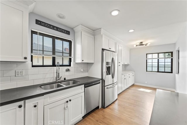 19408 Campaign Dr, Carson, CA 90746 - kitchen featuring appliances with stainless steel finishes, dark countertops, white cabinetry, decorative backsplash, and recessed lighting