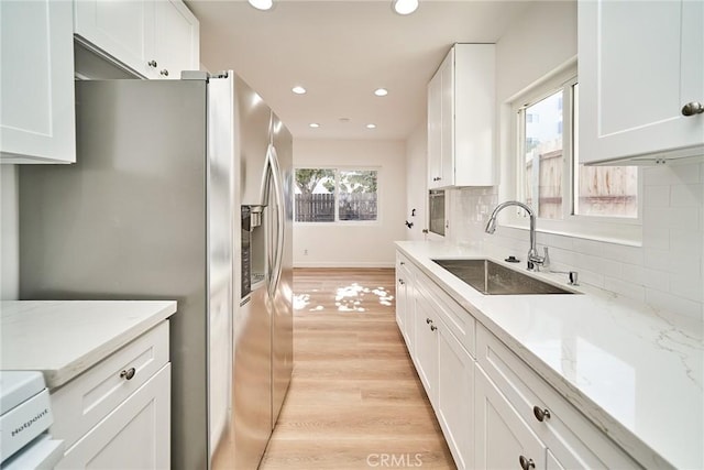 1103 S Hobart Blvd, Los Angeles, CA 90006 - kitchen with stainless steel fridge, white cabinetry, tasteful backsplash, light stone counters, and recessed lighting