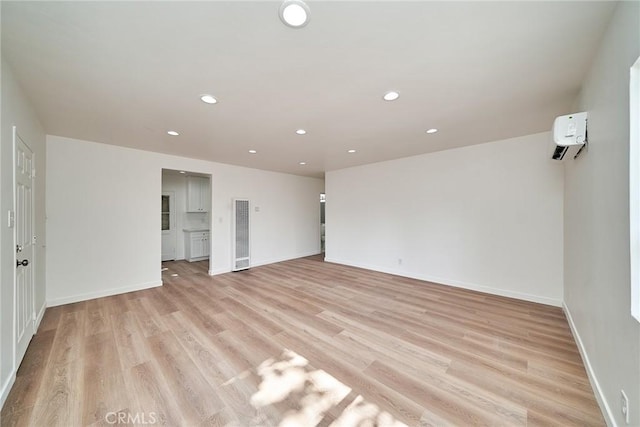 1103 S Hobart Blvd, Los Angeles, CA 90006 - spare room featuring a heating unit, light wood-type flooring, an AC wall unit, and recessed lighting