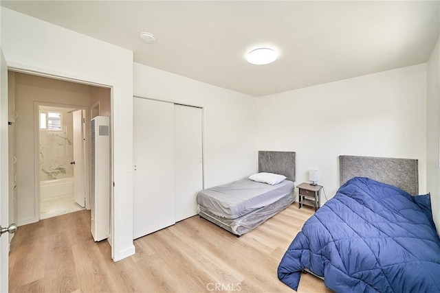 1103 S Hobart Blvd, Los Angeles, CA 90006 - bedroom featuring a heating unit, light wood-style floors, and a closet