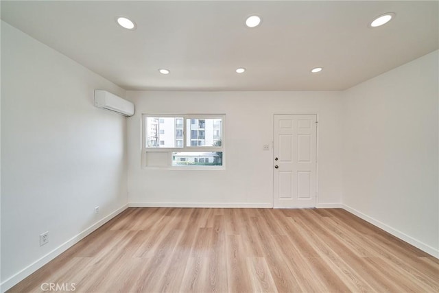 1103 S Hobart Blvd, Los Angeles, CA 90006 - unfurnished room with a wall mounted air conditioner, light wood-type flooring, and recessed lighting