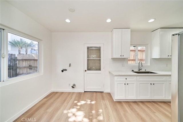 1103 S Hobart Blvd, Los Angeles, CA 90006 - kitchen with light countertops, light wood-type flooring, white cabinetry, tasteful backsplash, and recessed lighting