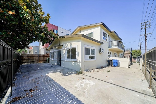 1103 S Hobart Blvd, Los Angeles, CA 90006 - rear view of house with a fenced backyard, stucco siding, a patio area, and a wall unit AC
