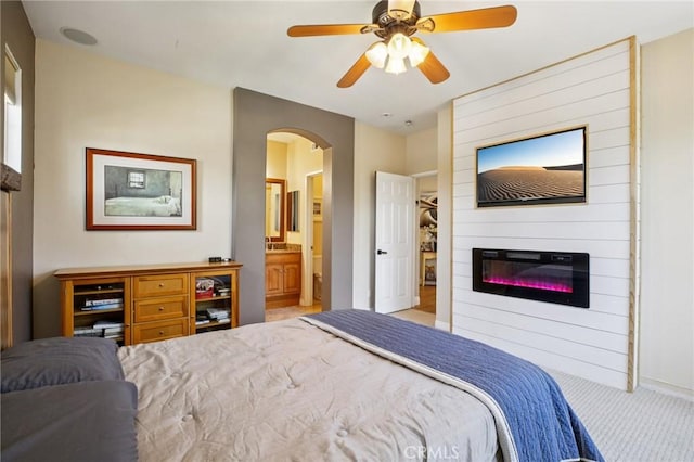 15 Ardmore, Irvine, CA 92602 - carpeted bedroom featuring arched walkways, a fireplace, connected bathroom, and ceiling fan