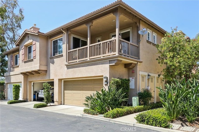 15 Ardmore, Irvine, CA 92602 - view of property featuring a balcony, a chimney, stucco siding, and a garage