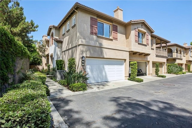 15 Ardmore, Irvine, CA 92602 - view of front facade featuring an attached garage, stucco siding, a chimney, driveway, and a tiled roof