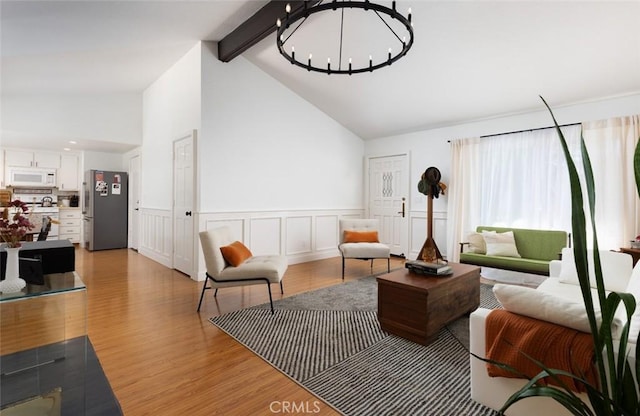 26645 Paseo Ensenada, San Juan Capistrano, CA 92675 - living room with a chandelier, light wood-type flooring, beam ceiling, a wainscoted wall, and high vaulted ceiling