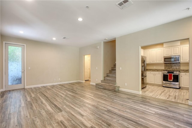 3591 Sacramento Dr Unit 50, San Luis Obispo, CA 93401 - unfurnished living room featuring stairs, light wood-style flooring, and recessed lighting