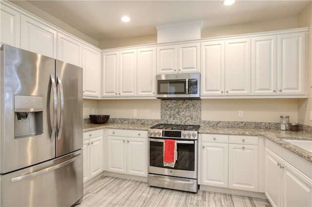 3591 Sacramento Dr Unit 50, San Luis Obispo, CA 93401 - kitchen with stainless steel appliances, white cabinets, recessed lighting, light stone counters, and decorative backsplash