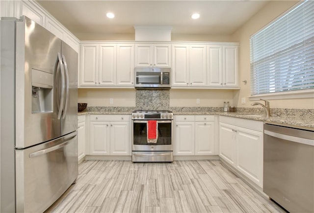 3591 Sacramento Dr Unit 50, San Luis Obispo, CA 93401 - kitchen featuring appliances with stainless steel finishes, white cabinets, recessed lighting, light stone counters, and decorative backsplash