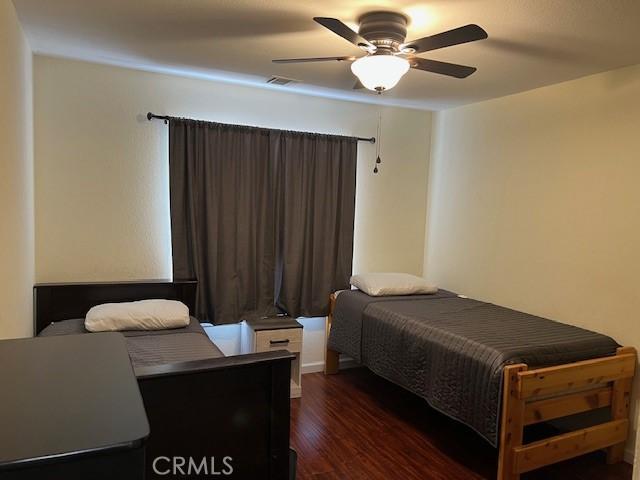 7653 Phelan Rd, Phelan, CA 92371 - bedroom featuring dark wood-style flooring and a ceiling fan
