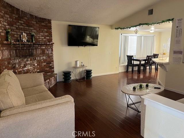 7653 Phelan Rd, Phelan, CA 92371 - living room featuring wood finished floors, lofted ceiling, and a textured ceiling