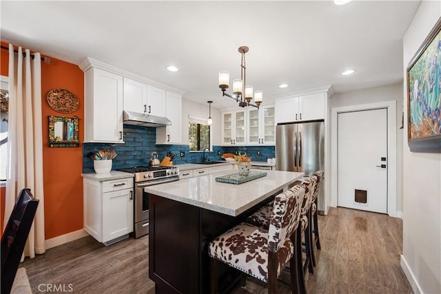 1024 Rachel Ln, Paso Robles, CA 93446 - kitchen with appliances with stainless steel finishes, under cabinet range hood, dark wood finished floors, glass insert cabinets, and white cabinets