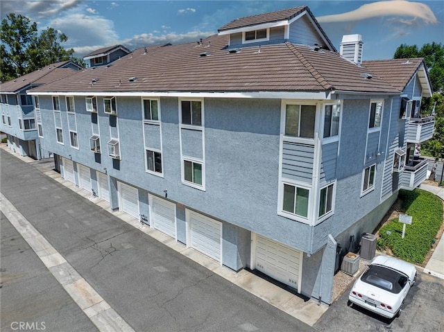 20334 Rue Crevier Unit 621, Canyon Country, CA 91351 - view of building exterior with an attached garage and asphalt driveway