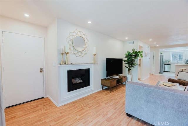 20334 Rue Crevier Unit 621, Canyon Country, CA 91351 - living area featuring light wood-style flooring, a glass covered fireplace, and recessed lighting