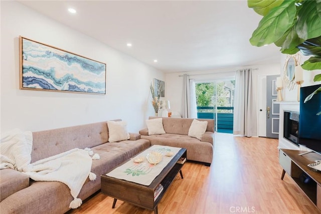 20334 Rue Crevier Unit 621, Canyon Country, CA 91351 - living room featuring light wood-style flooring, a glass covered fireplace, and recessed lighting