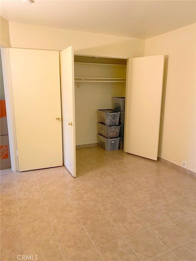 438 W Ramona Dr, Rialto, CA 92376 - unfurnished bedroom with a closet and light tile patterned floors
