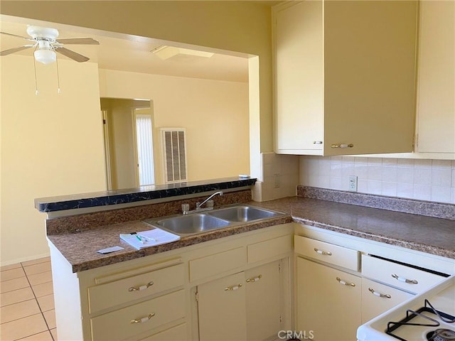 438 W Ramona Dr, Rialto, CA 92376 - kitchen featuring a peninsula, light tile patterned floors, tasteful backsplash, and dark countertops
