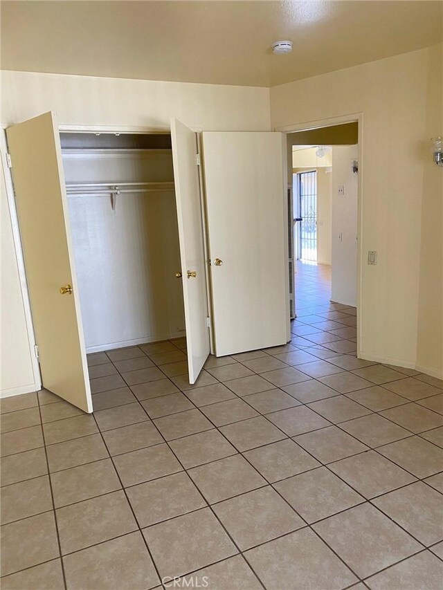 438 W Ramona Dr, Rialto, CA 92376 - unfurnished bedroom featuring light tile patterned floors and a closet