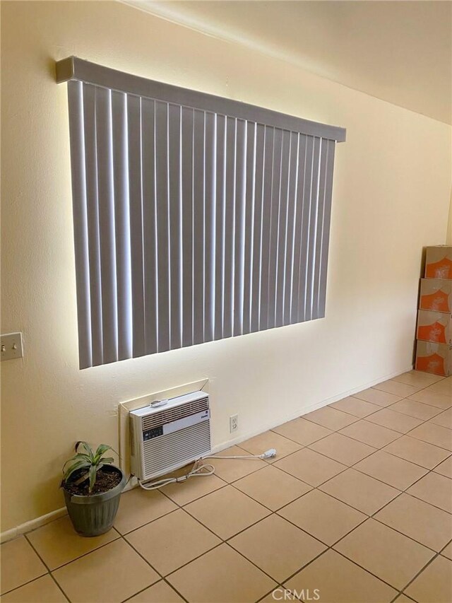 438 W Ramona Dr, Rialto, CA 92376 - empty room with an AC wall unit and light tile patterned floors