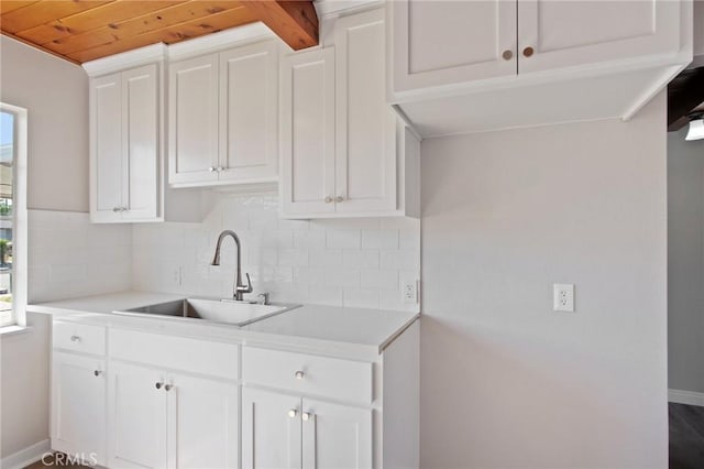 1625 Rose Ave, Merced, CA 95341 - kitchen with healthy amount of natural light, light countertops, backsplash, white cabinetry, and wood ceiling
