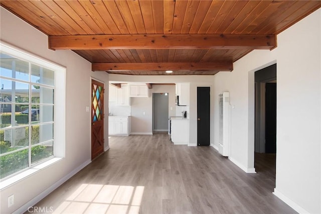 1625 Rose Ave, Merced, CA 95341 - empty room with plenty of natural light, a heating unit, a wood ceiling with exposed beams, and light wood-style flooring