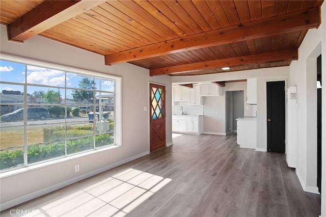 1625 Rose Ave, Merced, CA 95341 - unfurnished living room featuring plenty of natural light, a wood ceiling with exposed beams, and light wood finished floors