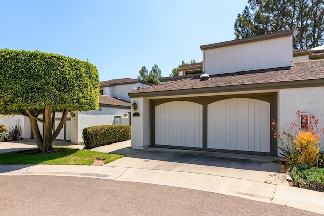 view of front of home with a garage and stucco siding