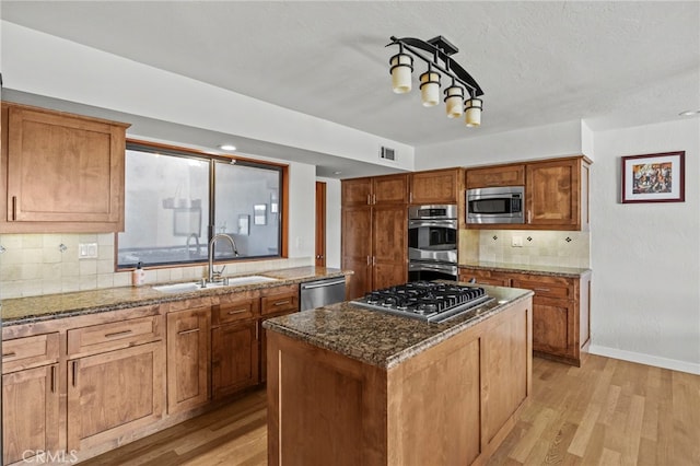 4 Woodhaven, Laguna Niguel, CA 92677 - kitchen featuring stainless steel appliances, light wood-style flooring, brown cabinets, tasteful backsplash, and dark stone countertops