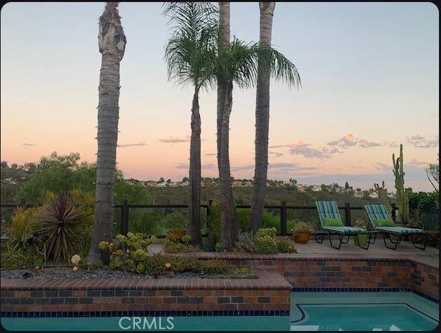 4 Woodhaven, Laguna Niguel, CA 92677 - pool at dusk featuring a patio area and an outdoor pool
