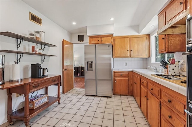5801 Repetto Ave, East Los Angeles, CA 90022 - kitchen with stainless steel refrigerator with ice dispenser, tile countertops, decorative backsplash, white gas cooktop, and recessed lighting