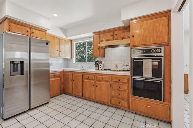 5801 Repetto Ave, East Los Angeles, CA 90022 - kitchen with stainless steel refrigerator with ice dispenser, under cabinet range hood, tasteful backsplash, and light tile patterned floors