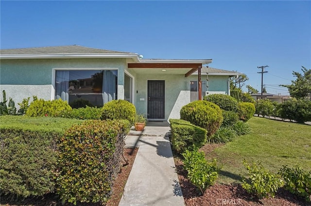 5801 Repetto Ave, East Los Angeles, CA 90022 - view of front facade with stucco siding and a front lawn