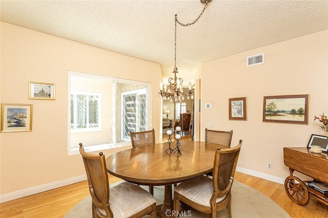 21094 Trailside Dr, Yorba Linda, CA 92887 - dining area featuring light wood finished floors, a chandelier, and a textured ceiling