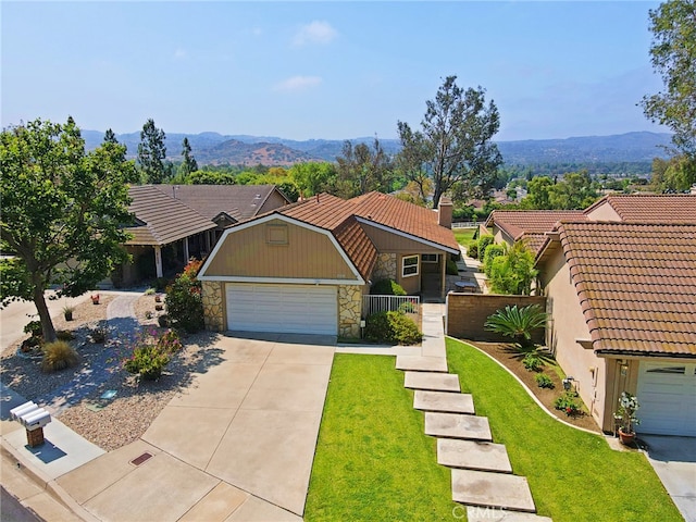 21094 Trailside Dr, Yorba Linda, CA 92887 - view of front of house with stone siding, a tile roof, a mountain view, and driveway