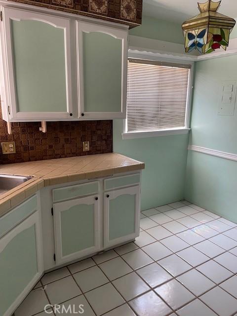 602 N Griffith Park Dr, Burbank, CA 91506 - kitchen featuring light tile patterned flooring, white cabinetry, and decorative backsplash