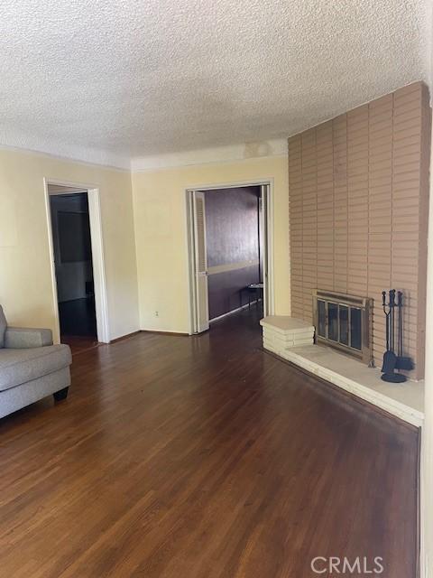 602 N Griffith Park Dr, Burbank, CA 91506 - unfurnished living room featuring a textured ceiling, dark wood-type flooring, and a fireplace