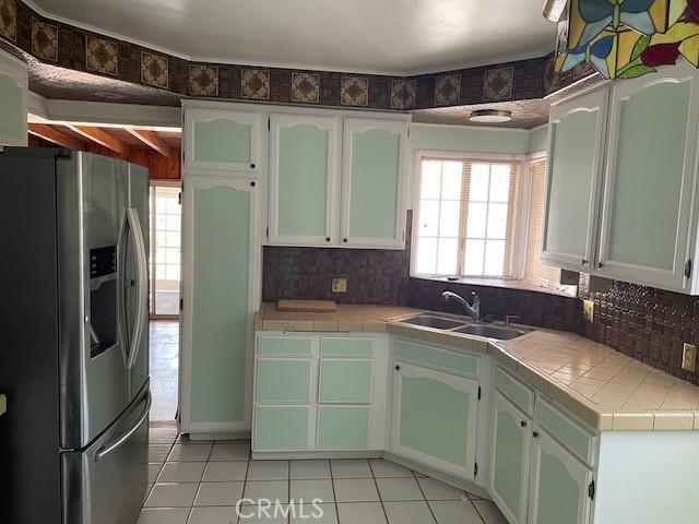 602 N Griffith Park Dr, Burbank, CA 91506 - kitchen featuring stainless steel refrigerator with ice dispenser, light tile patterned floors, tile countertops, and tasteful backsplash