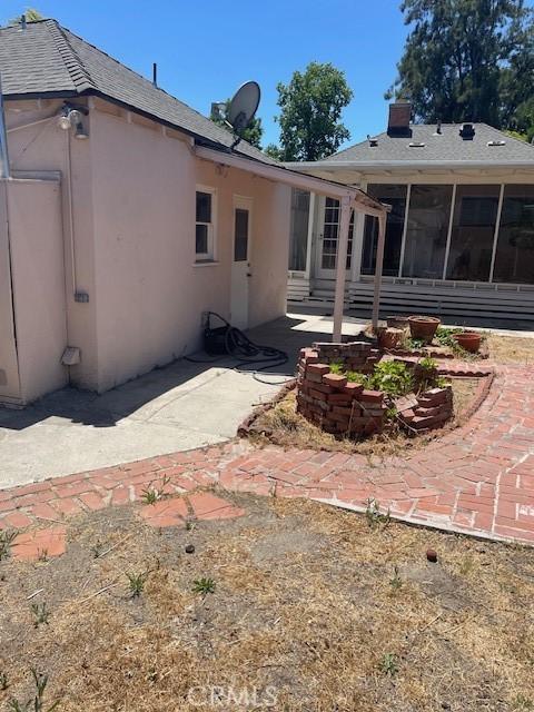 602 N Griffith Park Dr, Burbank, CA 91506 - rear view of property with a patio area, a sunroom, stucco siding, and a chimney
