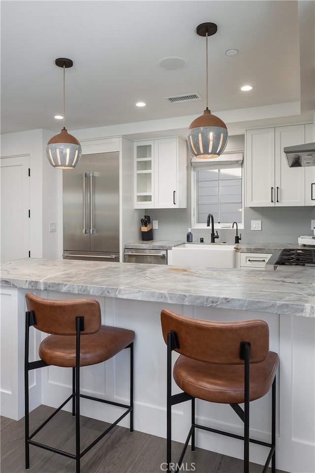 7141/2 Iris Ave, Newport Beach, CA 92625 - kitchen with stainless steel appliances, white cabinets, a kitchen bar, hanging light fixtures, and recessed lighting