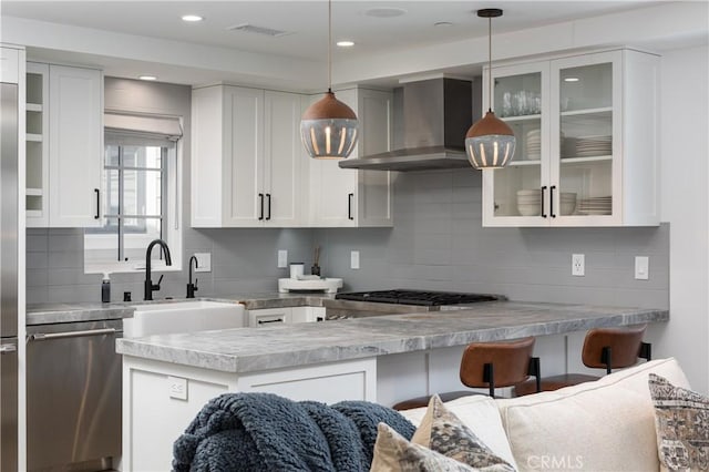 7141/2 Iris Ave, Newport Beach, CA 92625 - kitchen with stainless steel appliances, wall chimney exhaust hood, tasteful backsplash, white cabinetry, and glass insert cabinets