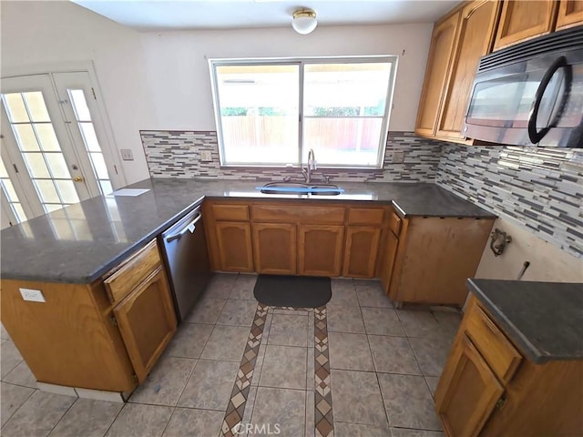 568 Walnut Ct, Kerman, CA 93630 - kitchen with black microwave, a peninsula, tasteful backsplash, brown cabinetry, and stainless steel dishwasher
