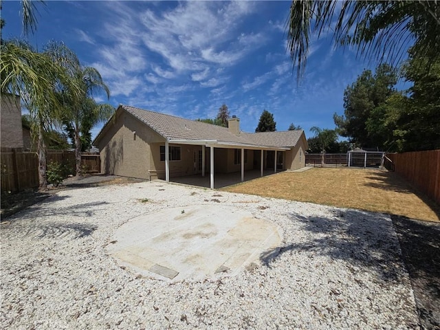 568 Walnut Ct, Kerman, CA 93630 - back of house with a chimney, a patio, a fenced backyard, stucco siding, and a tile roof