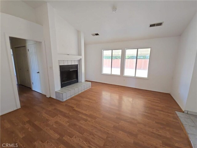 568 Walnut Ct, Kerman, CA 93630 - unfurnished living room with wood finished floors, a tile fireplace, and lofted ceiling