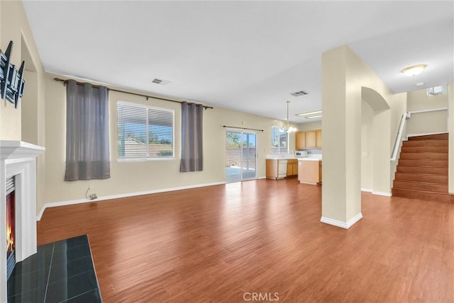 8305 Highridge Pl, Rancho Cucamonga, CA 91730 - unfurnished living room with wood finished floors, a fireplace with flush hearth, stairway, and a chandelier