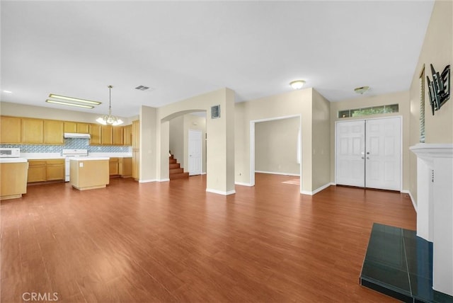 8305 Highridge Pl, Rancho Cucamonga, CA 91730 - unfurnished living room featuring arched walkways, dark wood-type flooring, a chandelier, and stairway