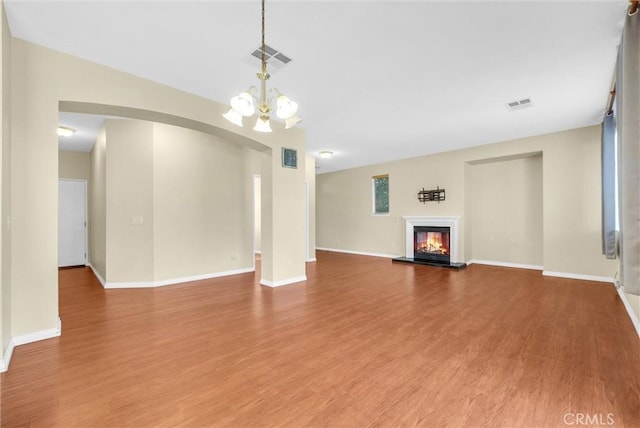 8305 Highridge Pl, Rancho Cucamonga, CA 91730 - unfurnished living room with arched walkways, wood finished floors, a chandelier, and a glass covered fireplace