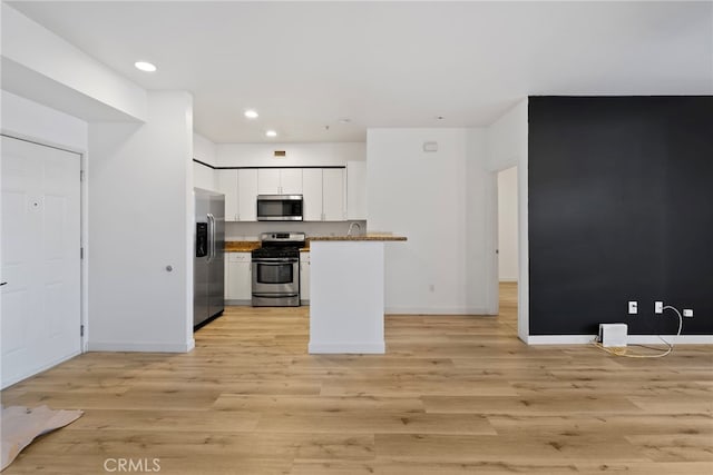 1801 E Katella Ave Unit 1091, Anaheim, CA 92805 - kitchen with appliances with stainless steel finishes, white cabinetry, light wood-style flooring, recessed lighting, and open floor plan